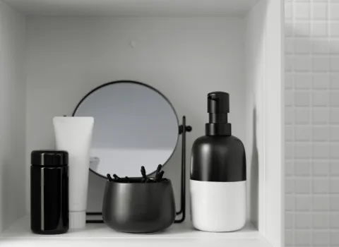 Ein offenes Regal OSIL035 der Serie Eqio von burgbad beherbergt Pflegeprodukte in ästhetischer schwarz-weiß Farbabstimmung..