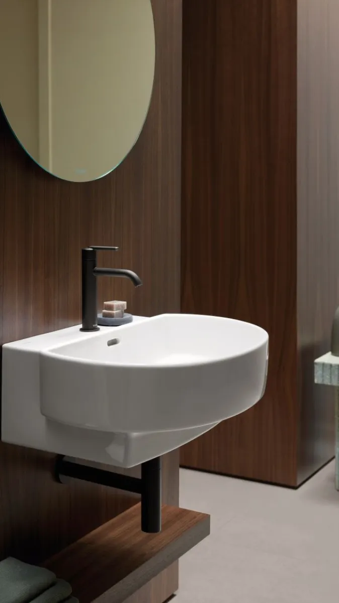 Wandhaengendes Waschbecken der Serie Balcoon von Duravit vor einer dunklen Holzwand.